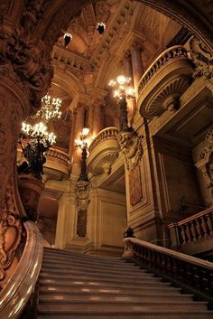 an ornate staircase with chandeliers in a building