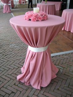 a table with pink cloth and flowers on it