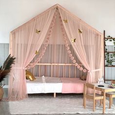 a bedroom with a pink canopy bed and curtains