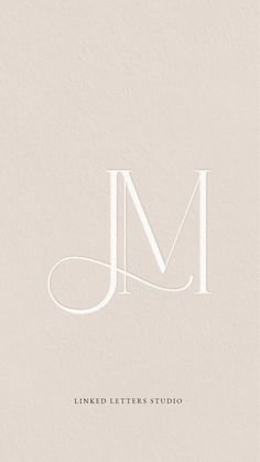 the letter m is shown in white on a beige background with an elegant monogram