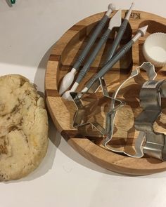 an assortment of cookie cutters and other kitchen utensils on a wooden tray