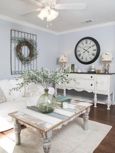 a living room filled with furniture and a large clock on the wall above it's mantle