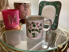 a glass table topped with two coffee mugs and other decorative items on top of it