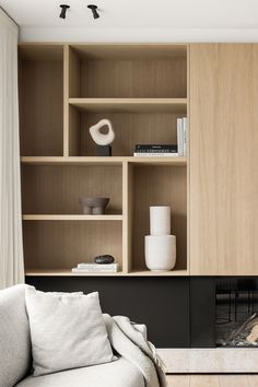 a living room filled with furniture and a fire place in front of a book shelf