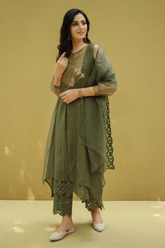 Moss green kurta with tissue insert in the centre, accented with a hand crafted flower in gold on the side. Paired with flower lace work pant. Comes with scallop trimmed dupatta.
Component: 3
Pattern: Embroidery
Type Of Work: Schiffli Embroidery
Neckline: Round Neck
Sleeve Type: Three Fourth Sleeves 
Fabric: Cotton, Chanderi, Organza 
Color: Green
Other Details: 
Sheer and cuffed sleeves
Scallop trimmed hem pant
Drawstring waist
Note: Slip worn by the model is not for sale
Occasion: Mehendi and Yale Blue, Embroidery Neckline, Kurta Patterns, Blue Kurta, Kurta Set For Women, Embroidered Sleeves, Embroidered Dupatta, Scallop Trim, Pattern Embroidery