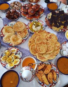 a table topped with plates and bowls filled with food