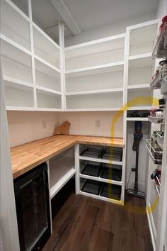 a kitchen with white cabinets and wood flooring in the center is an open pantry