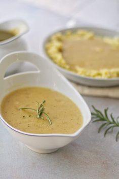 there is a bowl of soup on the table next to other bowls and pies