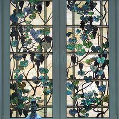 a stained glass window with vines and leaves