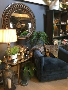 a living room filled with furniture and a large round mirror on top of the wall