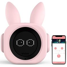 an alarm clock with bunny ears on it next to a cell phone and earphones