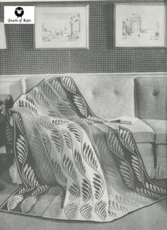 a black and white photo of a blanket on a couch with a chair in the background