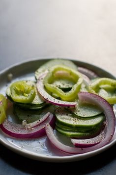 sliced cucumbers and onions on a white plate