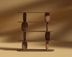 a shelf made out of wood with circles on the top and bottom, sitting in front of a tan wall