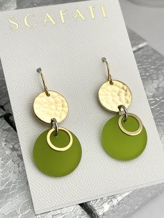 "The round link is plated with glossy 18K gold . The finish is glossy because it is rack plated. This means that the pieces are hand hung so they receive the optimal amount of coverage. Hanging from the link is a sea glass round drop with 18K gold barrel plated rings. The sea glass comes in five different colors as follows: 1) Lime Green 2) Turquoise 3) Teal 4) Mint Green 5) Navy The earrings are lead safe. The ear wires are 16 K gold plated with rubber back stoppers. The full length of the earr Gold Round Disc Earrings For Pierced Ears, Nickel Free Round Green Earrings, Elegant Metal Round Disc Earrings, Gold Round Disc Earrings, Elegant Green Circular Earrings, Green Round Earrings, Green Circular Metal Jewelry, Modern Green Nickel-free Earrings, Modern Green Earrings With Polished Finish