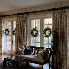 a living room filled with furniture and christmas wreaths