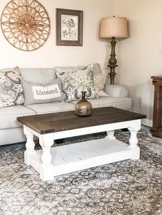 a living room with a couch, coffee table and two lamps on either side of the couch