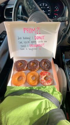 a box filled with donuts sitting inside of a car