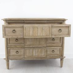 an old wooden dresser sitting on top of a hard wood floor next to a white wall