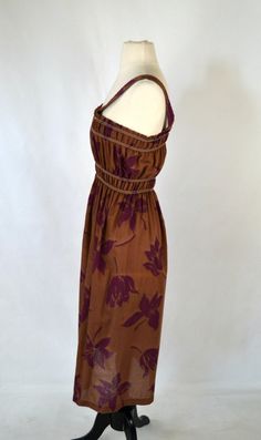 1970's Brown and Purple Hibiscus Sundress Brown dress with large dark purple hibiscus print over this lovely sundress. There is elastic at the bust and waist to fit several dress sizes. Label: Unknown - No Tag Present Measurements are taken flat; Armhole: 8 inches Neck: 7 inches Bust: 9 1/2 - 17 inches Waist: 8 - 18 inches Hips: 15 inches Length (shoulder to hem): 44 inches Condition Just below the hip line is a faded circle that goes around the skirt. Vintage is anything over 20 years old, I tr Fitted Brown Sundress With Floral Print, Fitted Brown Floral Print Sundress, Vintage Brown Maxi Dress For Beach, Vintage Brown Dress For Vacation, Vacation Brown Floral Print Sundress, Retro Brown Dress For Vacation, Purple Sundress, Purple Hibiscus, Hibiscus Print