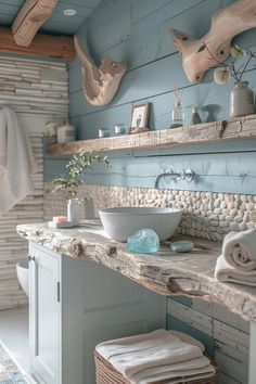 a bathroom with blue walls and stone counter top, white sink and wooden shelving