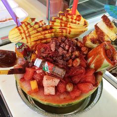 a watermelon filled with lots of different types of food on top of a counter