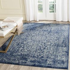 a large blue rug with an ornate design on the floor in front of a window