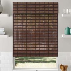 a kitchen window covered in brown blinds and wooden utensils next to a sink