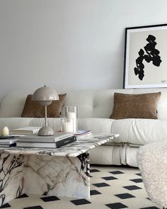 a living room with white furniture and black and white checkered floor tiles on the floor