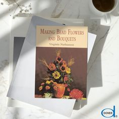 two books sitting on top of a table next to a cup of coffee and an orange vase