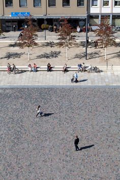 people are sitting on benches and walking down the street