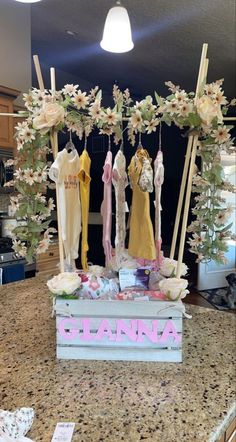 an arrangement of clothes and flowers on display in a kitchen with the name lanana