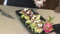 a person holding a knife and fork over a plate of food on a counter top