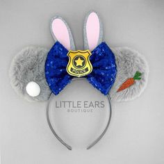 a gray and blue mouse ears headband with a badge on it