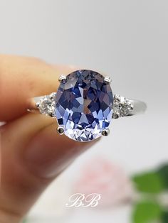 a person holding a blue and white diamond ring