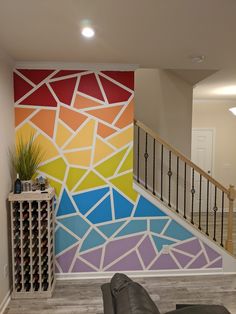 a living room filled with furniture and a painting on the wall next to a stair case