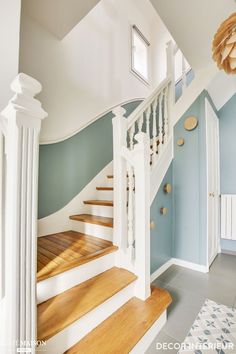 a white staircase with blue walls and wooden steps leading up to the second floor area