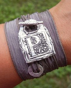 a close up of a person's arm wearing a bracelet with a silver clasp