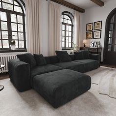 a living room with large black couches and windows