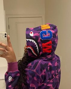 a woman taking a selfie in front of a mirror wearing a bathing suit with a shark head on it