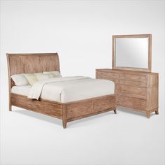 a wooden bed sitting next to a dresser with a mirror on it's side