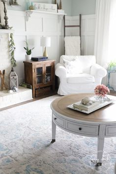 a living room filled with furniture and a fire place next to a white couch in front of a fireplace