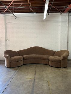 a curved couch sits in an empty room