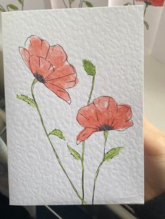 a hand holding up a card with watercolor flowers on it