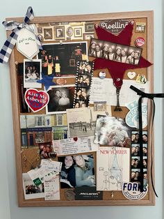 a bulletin board covered in pictures and magnets with ribbons on the bottom, along with other items