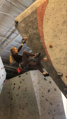 a woman climbing up the side of a rock wall