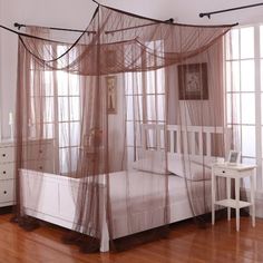 a white bed sitting on top of a hard wood floor