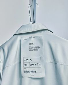 the back of a white shirt with a label on it