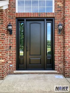 a black front door with two sidelights and brick walls on the outside of a house