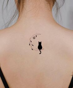 a woman's back with a cat tattoo on her left shoulder and the moon behind it